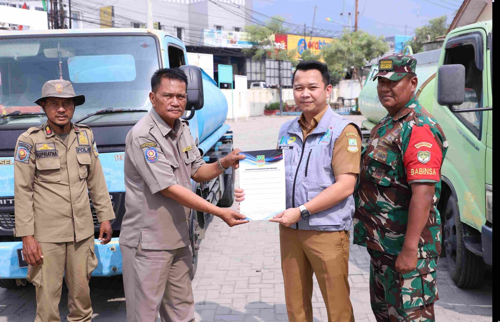 Kepala Bidang Informasi dan Komunikasi Publik (IKP) Diskominfosantik Kabupaten Bekasi, Rhamdan Nurul Ikhsan, secara simbolis menyerahkan bantuan 10.000 liter air bersih untuk warga Desa Hurip Jaya